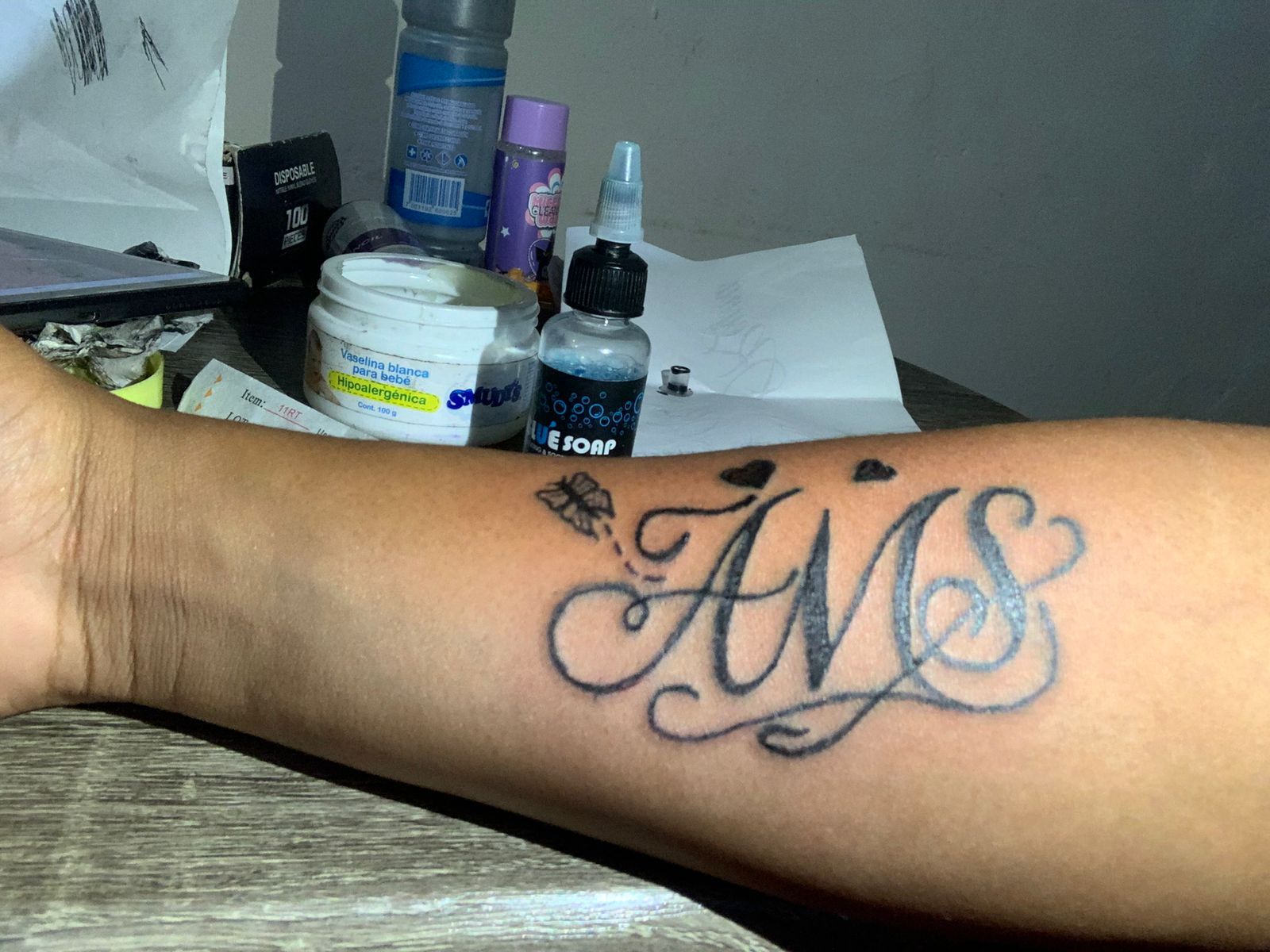 Tatuaje lettering AWS con mariposa y corazones